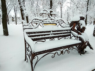 A snow-covered bench with a fairy-tale character