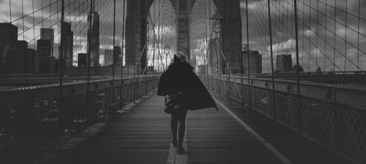 Woman walking on the Brooklyn bridge in the wind