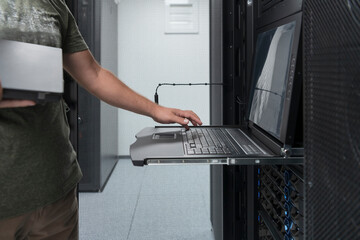 Close up on Data Center Engineer hands Using keyboard on a supercomputer Server Room Specialist...