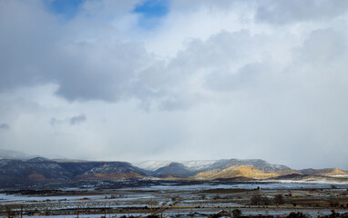 Hazardous winter weather along a high rocky mountains on I-40 highway with winter snow covered landscape in the New Mexico