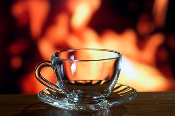 glass cup of black tea on a background of fire