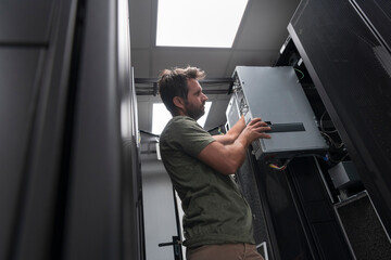 IT engineer working In the server room or data center The technician puts in a rack a new server of...