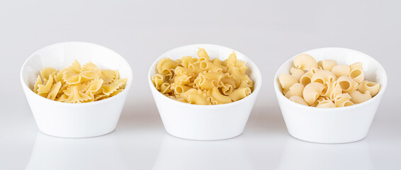 Pasta in a white bowl, isolated on a white background with reflection.