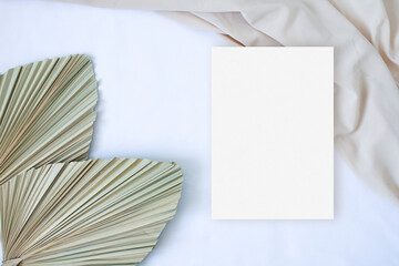 Mockup card with leaf palm and nude fabric on the white background