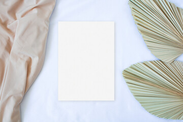 Mockup card with leaf palm and nude fabric on the white background