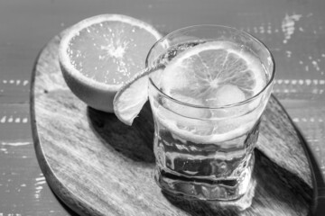 Cold summer delicious coctail with lime and ice in a glass with drops on the white and blue background.