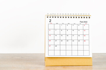 February 2022 desk calendar on wooden background.