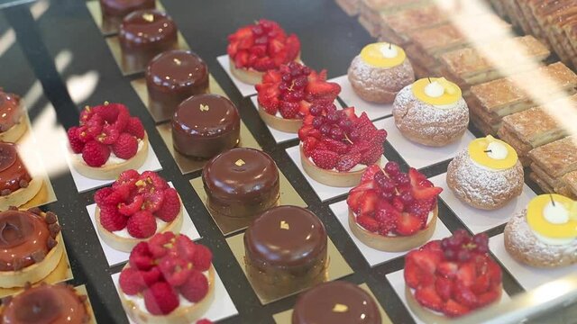 Pano right over assortment luxurious pastries and tarts in counter of a bakery shop
