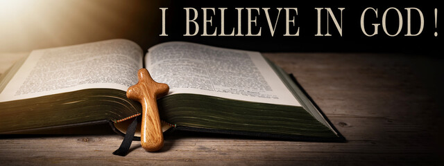 I believe in GOD ! Church faith Christian background banner panorama - Old holy bible and cross on old rustic vintage wooden table and sunshine light - obrazy, fototapety, plakaty