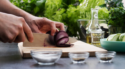 close-up male hands are preparing food in the interior of a kitchen.