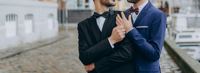 Gay Couple wearing black and blue suits, happy day of a same sex couple. Wedding photography.