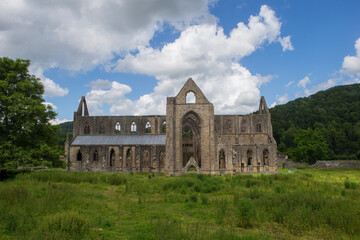 Image of the remains and ruins of the famous Tintern Abbey in Monmouthshire, Wales. Landscape image with farm fields.