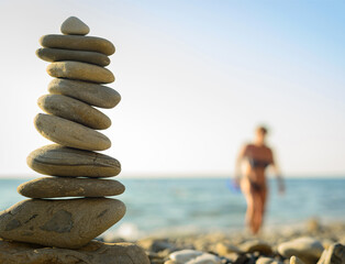 Fototapeta na wymiar beach pebble stones pyramid on sea shore