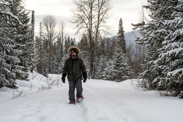 Fototapeta na wymiar Man Snowshoeing in the Forest 