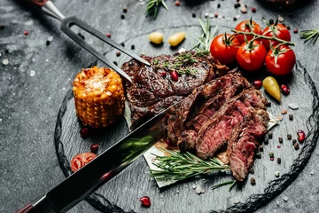 Foto op Canvas Grilled ribeye beef steak with rosemary, fork and knife. banner, menu, recipe place for text, top view © Надія Коваль