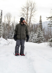 Fototapeta na wymiar Man Snowshoeing in the Forest 