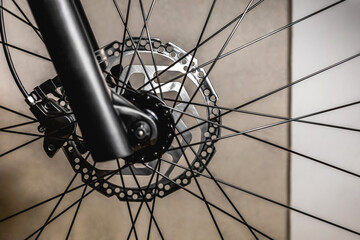 Mountain bike front hydraulic disc brake with cable on black spoked wheel fork
