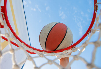dunking basketball ball through net ring with hand, basketball © Olena