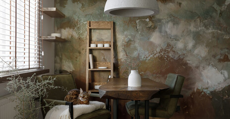 Stylish interior design of dining room with solid oak table, oak shelf and green chairs, bengal...