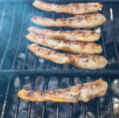 Panceta / bacon a la brasa, barbacoa o parrilla (tocino fresco) humeando (humo) al fuego