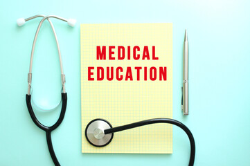 The red text MEDICAL EDUCATION is written in a yellow pad that lies next to the stethoscope on a...