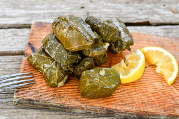 Dolmades - stuffed grape leaves  rolls  with rice the Greek way on wooden table .Stuffed greek wine leaves