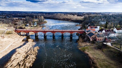 old brick bridgeand waterfall on the river in spring