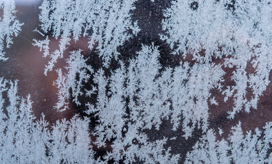 Grey snow and frost on car glass with blur effect.