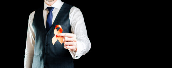 Hiv day. Red ribbon in hiv world day isolated on black background. Man holding awareness aids and cancer symbol. Aging Health month concept.
