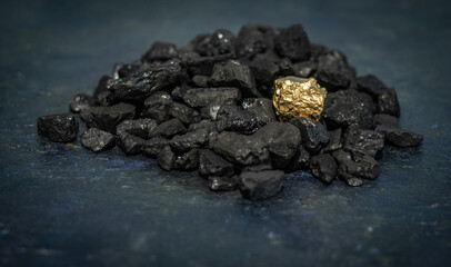 hard coal in the pile. a piece of gold among the coal. extracted underground.