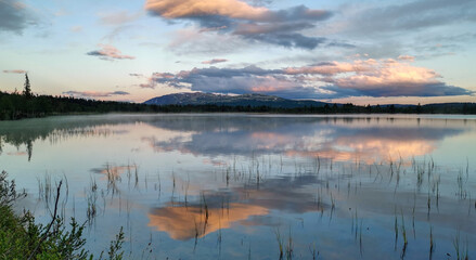 tranquil landscape scenery during blue hour with reflections in water and pink skies.