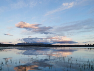 Fototapeta premium tranquil landscape scenery during blue hour with reflections in water and pink skies.