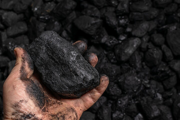 a lump of hard coal held in hand