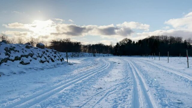 Winter landscape with snow and cross-country skiing trail on the meadow. Sunny day on the countryside this cold day. Footage made in Sk&aring;ne, Sweden.