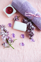 Obraz na płótnie Canvas spa theme. beauty and health. a set of towels, white soap and a lilac branch. color of the year 