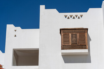 Obraz premium Closed window with wooden bars in an old white wall of a house on the street of Egypt in Sharm El Sheikh