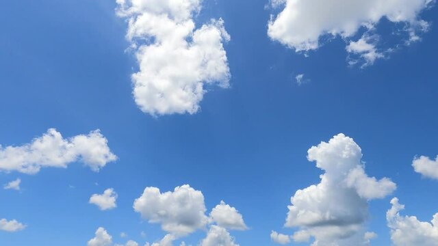 Sunny clear blue sky with fluffy white clouds
