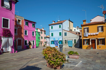 Sunny day among the colorful houses of the Burano island. Venice, Italy