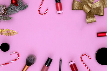 Happy New Year. Golden numbers, fir branches and cosmetics on a pink background. the concept of a postcard makeup artist with a top view