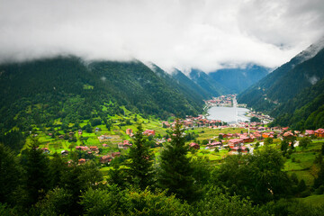 Greenery with stunning mountain lake with turquoise water with beautiful homes in mountains village Uzun Gol in Karadeniz - obrazy, fototapety, plakaty
