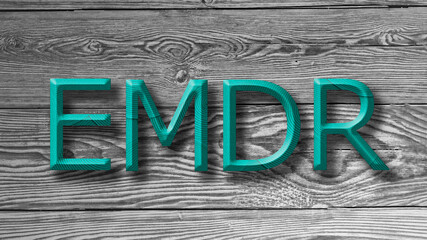 Letters EMDR written on wooden gray background. Eye Movement Desensitization and Reprocessing psychotherapy treatment concept.