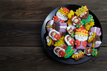 Happy Epiiphany day. Homemade cookies in the shape of the three wise men on wooden background.