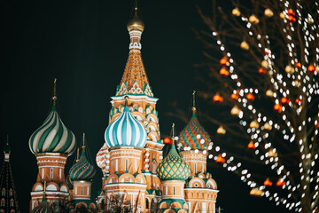 Obraz premium Christmas night on the Red square. New Year's Eve at the Kremlin walls. near St. Basil's Cathedral. Blur of people walking.