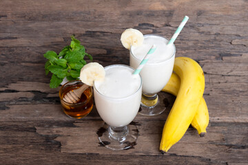 Banana fresh cocktail vanilla smoothies  fruit juice beverage healthy the taste yummy in glass drink episode good morning on wooden background from the top view.