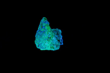 macro mineral stone opal under ultraviolet light on a black background