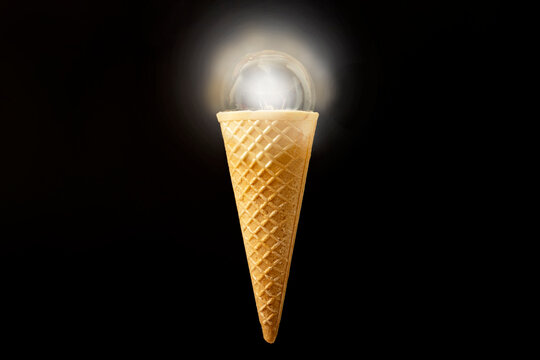 Lit light bulb, in a ice cream cone, isolated on black background