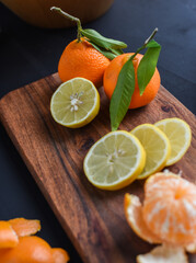 Orangen geschnitten auf dunklem Hintergrund, verschiedene Citrusfrüchte geschnitten, geschält, zerteilt