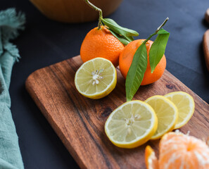 Fototapeta na wymiar Orangen geschnitten auf dunklem Hintergrund, verschiedene Citrusfrüchte geschnitten, geschält, zerteilt