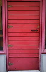 Fototapeta na wymiar A old door painted of pink in the city