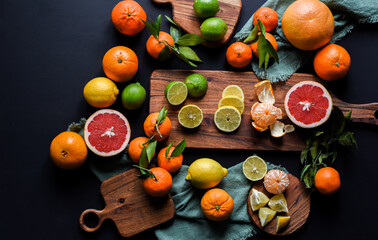 Frische Orangen auf schwarzem Hintergrund, Auswahl Orange, Mandarine, Zitrone, Limette,...